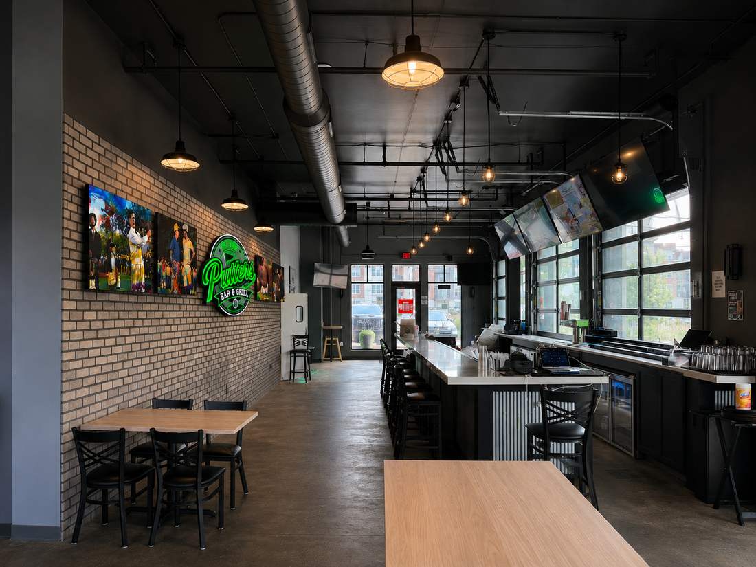 View down the main bar with overhead TVs and garage-door windows